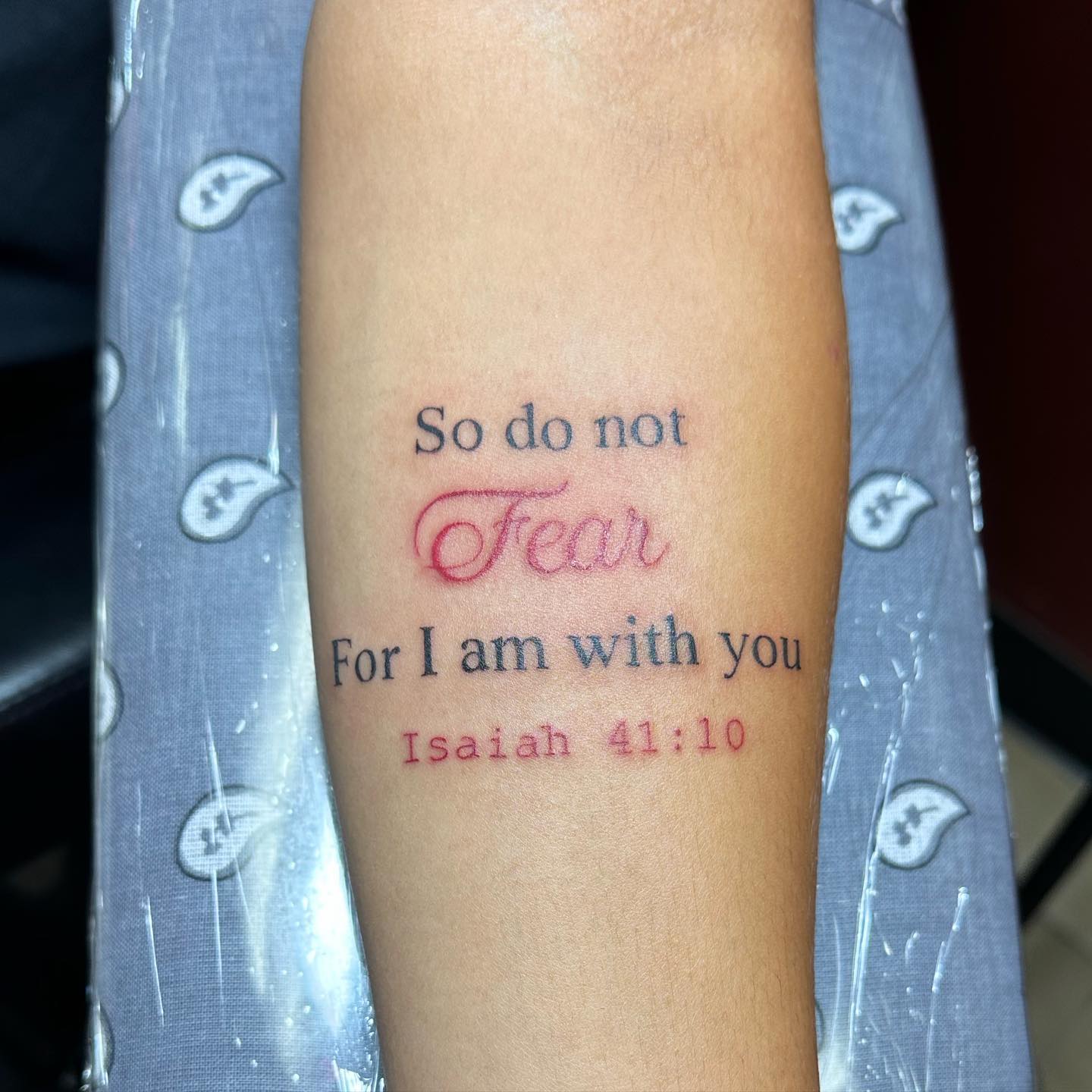Isaiah 41:10 scripture tattoo with red script lettering