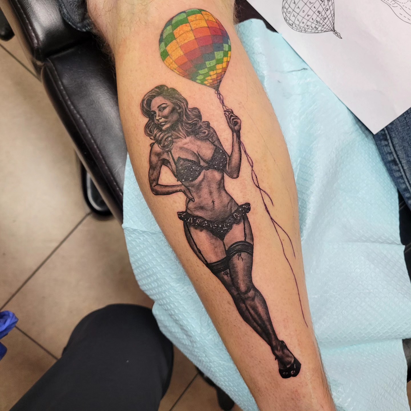 Black and grey pin-up with color balloon tattoo on calf