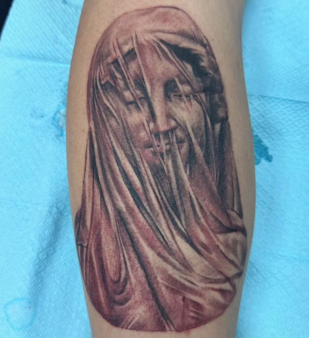 Black and grey veiled figure realism tattoo on calf