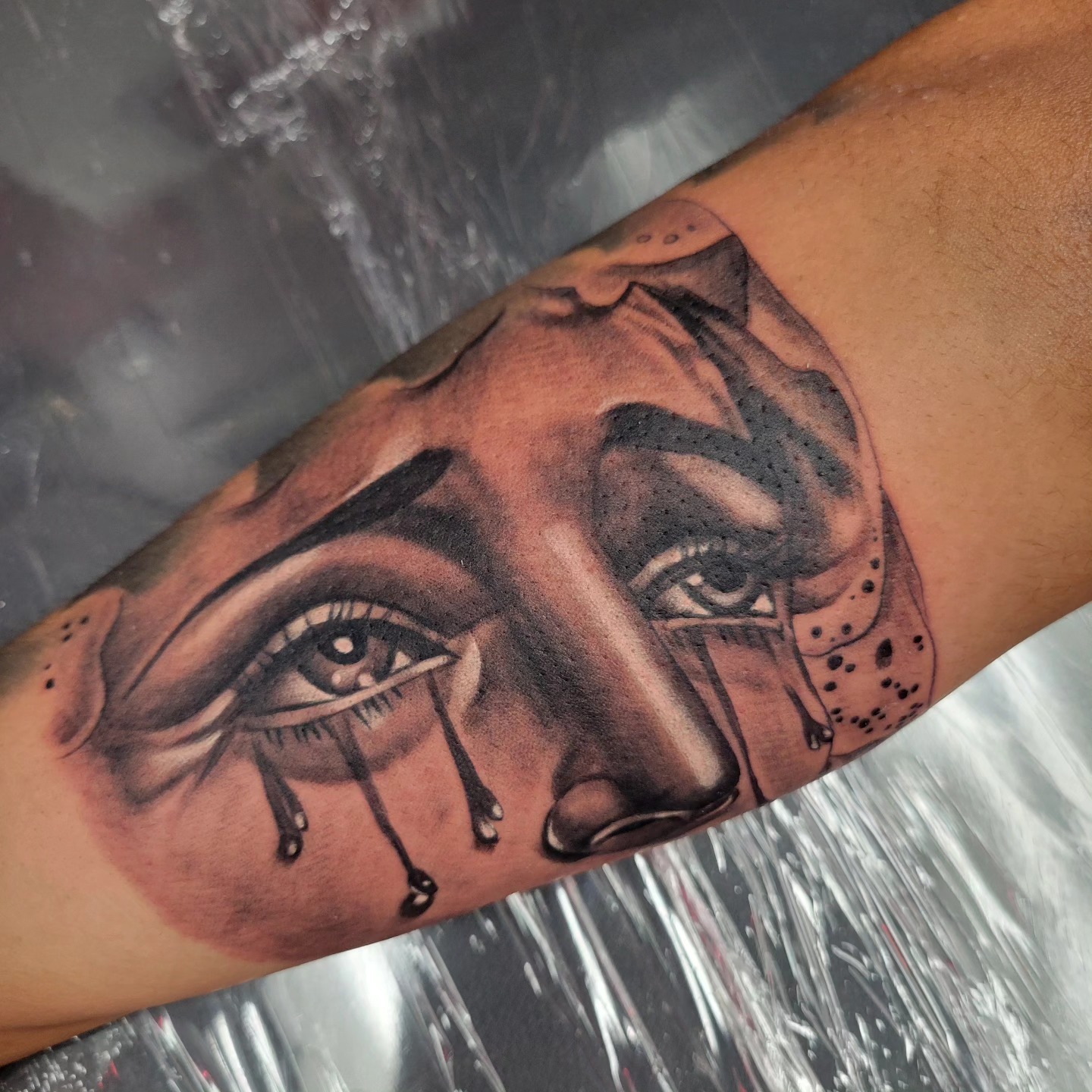 Black and grey crying eyes portrait tattoo on forearm