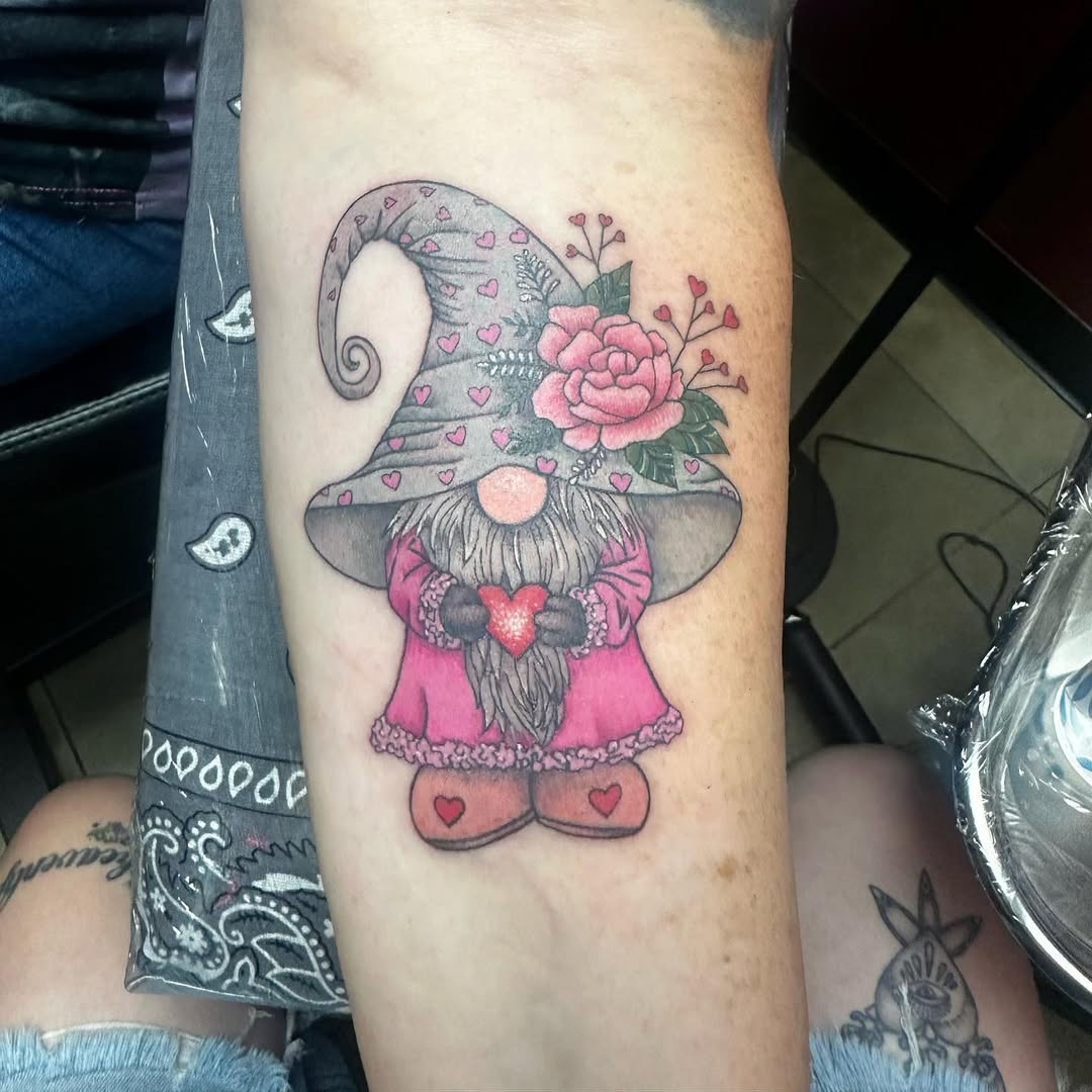 Color gnome with rose and hearts tattoo on forearm
